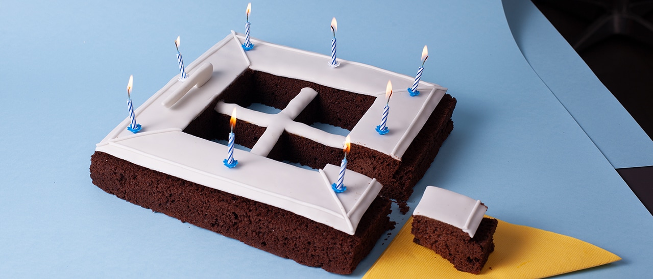 40 Jahre Jubiläum bei Schmidinger – Jubiläumskuchen in Fensterform mit Zuckerglasur und Kerzen auf blauem Tisch.