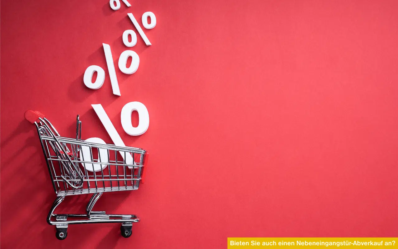 Ein kleiner Einkaufswagen vor rotem Hintergrund mit fallenden Prozentzeichen; symbolisiert Rabattaktionen und Abverkauf.