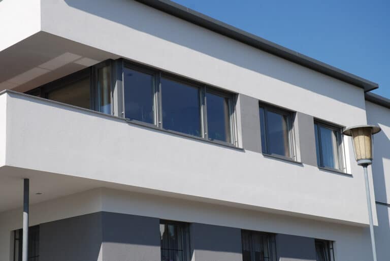 Fensterband in Anthrazit im Obergeschoß über der weißen Balkonbrüstung