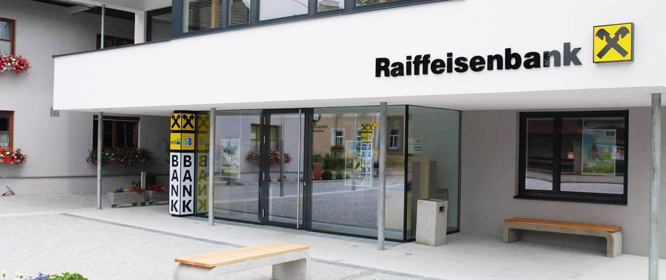 Aluminium-Portale für Geschäfte und Bankfilialen mit großer Glasfront und automatischer Eingangstür am Beispiel einer Raiffeisenbank.
