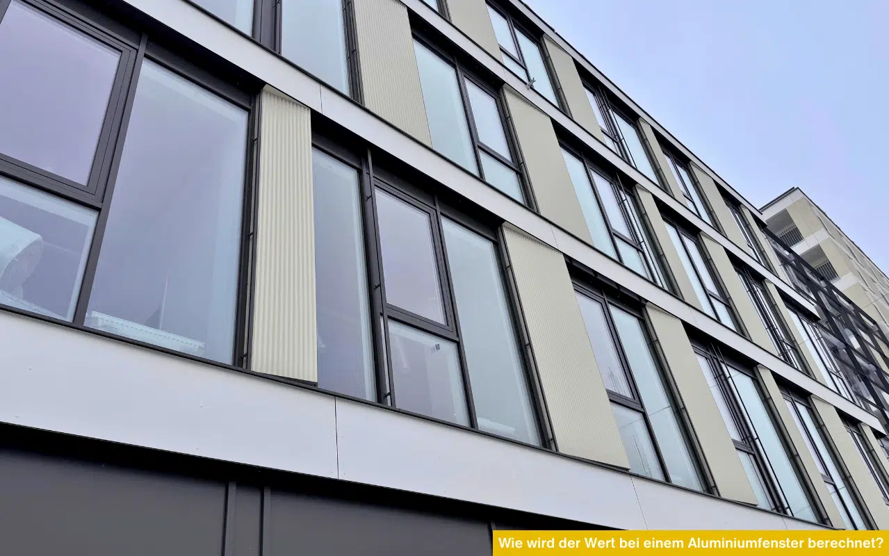 Untersicht einer modernen Bürofassade mit großen Aluminiumfenstern – Fokus auf Wärmedurchgangskoeffizienten.