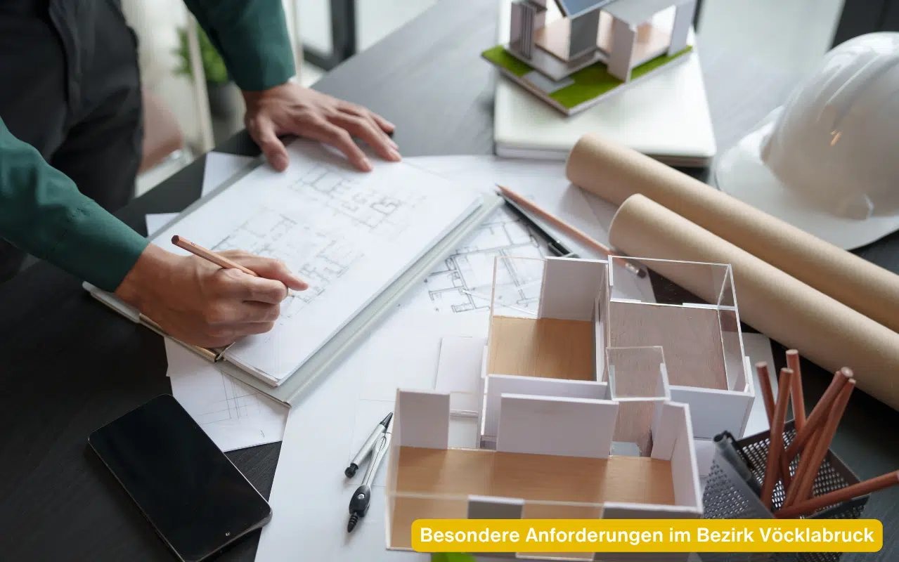 Architekt plant Projekt für besondere Anforderungen im Bezirk Vöcklabruck mit Bauplänen und Architekturmodell.