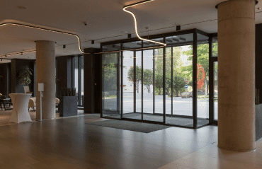 Automatische Schiebetür aus Glas für helle Empfangshalle mit moderner Innenarchitektur und großen Fensterfronten