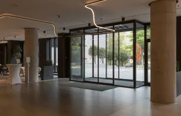 Automatische Schiebetür aus Glas für helle Empfangshalle mit moderner Innenarchitektur und großen Fensterfronten