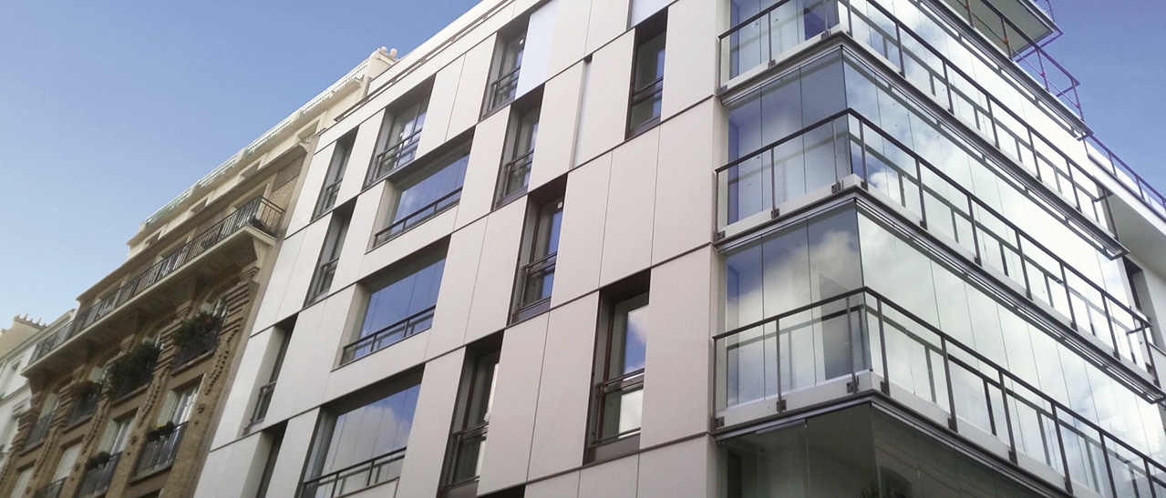 Ein modernes Wohngebäude mit großen Glasfronten und individuell angepassten Balkonwintergärten. Die Glasverkleidung schützt vor Wind und Wetter und erweitert den Wohnraum mit lichtdurchfluteter Atmosphäre.