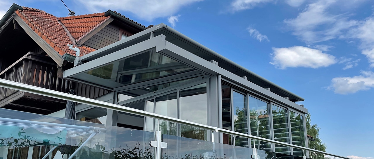 Aufglas-Markise auf modernem Wintergarten schützt Glasdach effektiv vor Sonnenstrahlen und sorgt für angenehme Temperaturen im Sommer.