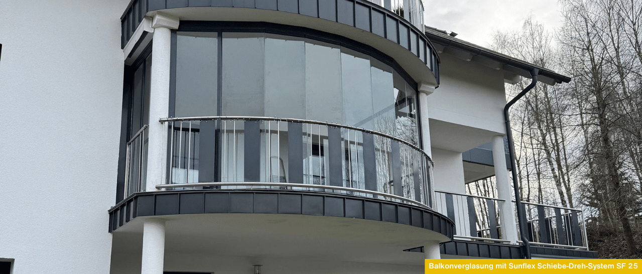 Balkonverglasung in Oberösterreich mit rahmenlosem Schiebe-Dreh-System für ganzjährige Nutzung und optimalen Wetterschutz