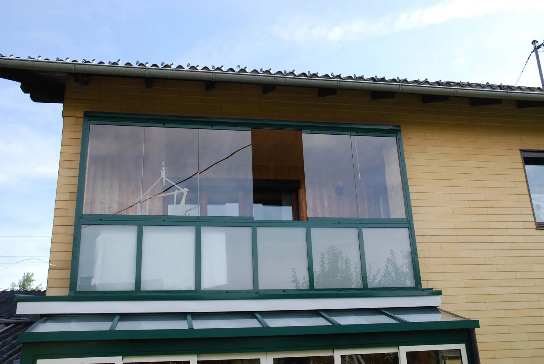 Balkonverglasung mit rahmenlosen Faltfenster