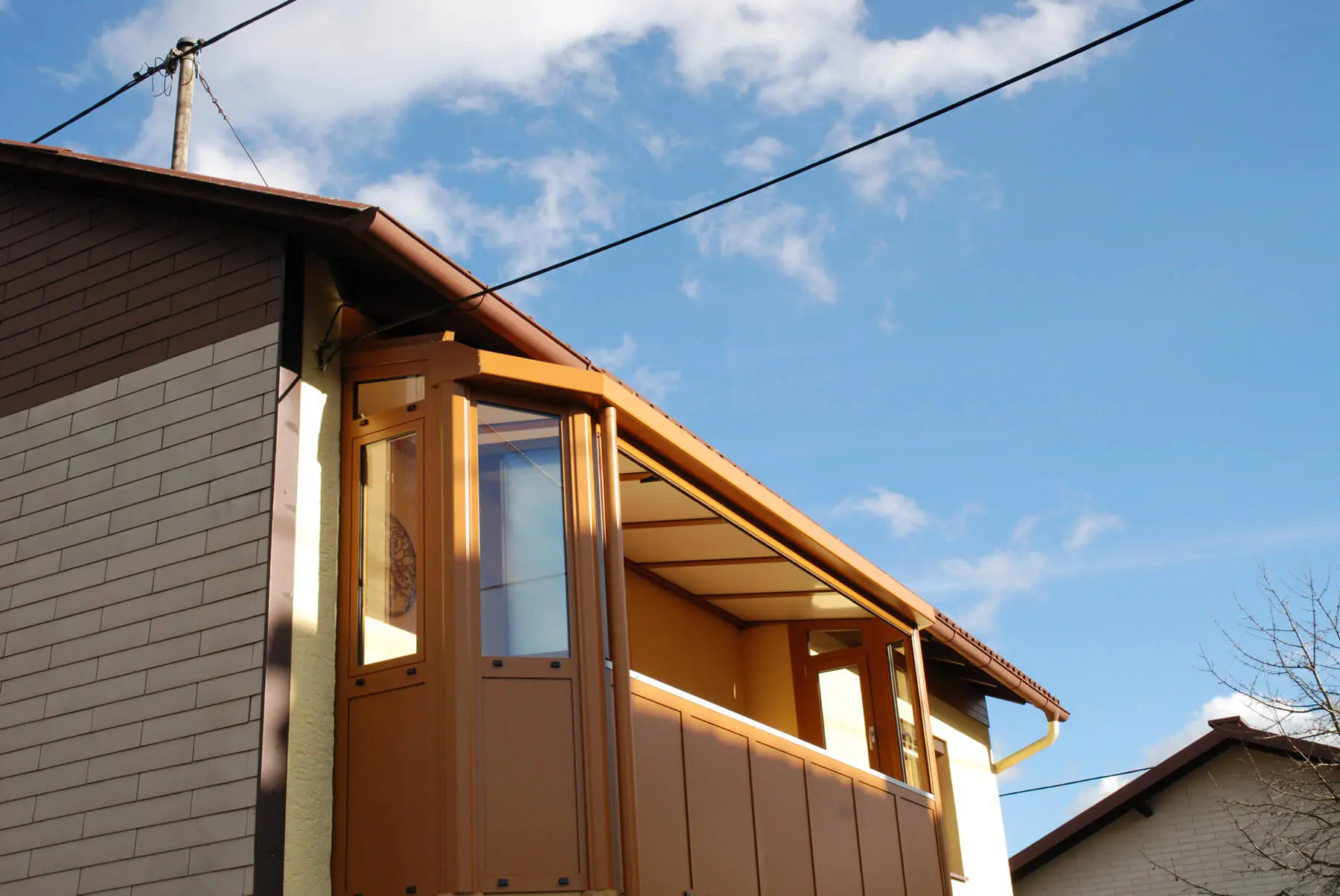 Balkonverglasung ockerbraun mit Seitenteilen und geschlossenem Dach