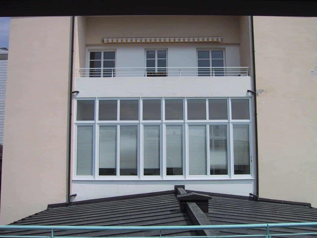 Weißer Balkonverbau mit Verglasung nach Maß an einer Hausfassade in Bad Ischl