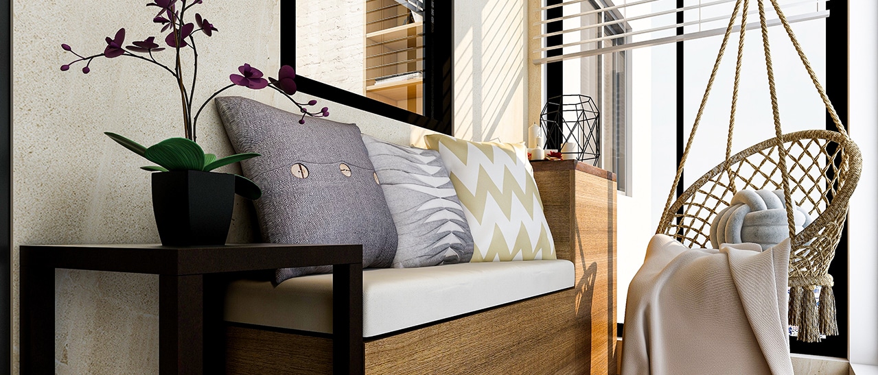 Das Bild zeigt einen verglasten Balkon mit Sitzbank, Kissen und Hängesessel. Durch die Balkonverglasung entsteht eine gemütliche, lichtdurchflutete Wohlfühloase - ideal zum Entspannen, Lesen oder Kaffeetrinken.