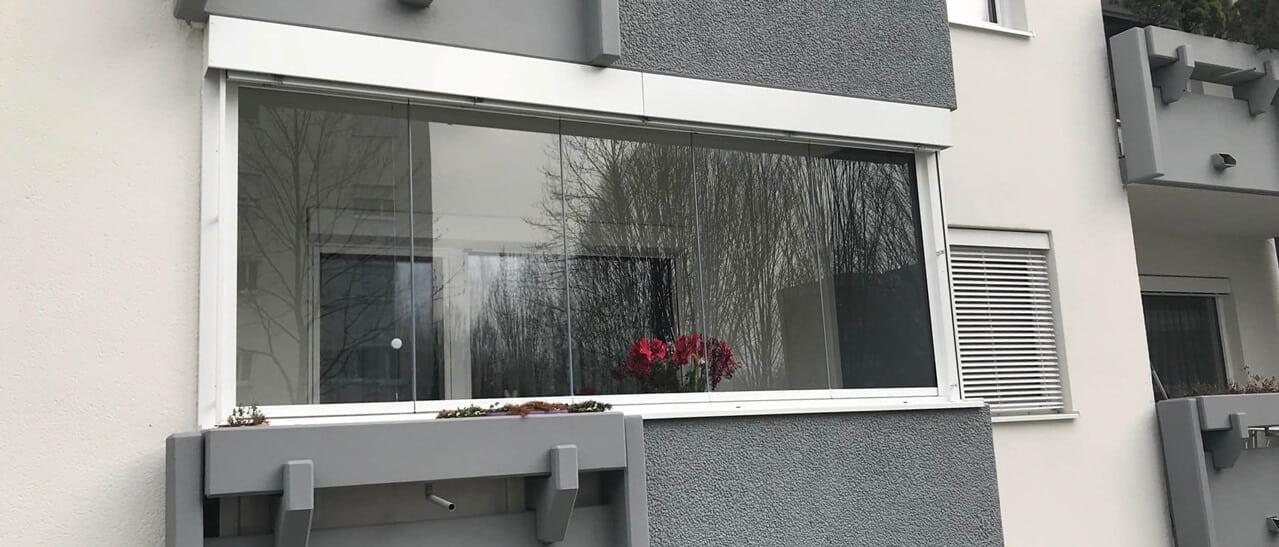 Das Bild zeigt eine nachträgliche Balkonverglasung, die den Außenbereich ganzjährig nutzbar macht und das Gebäude optisch aufwertet.