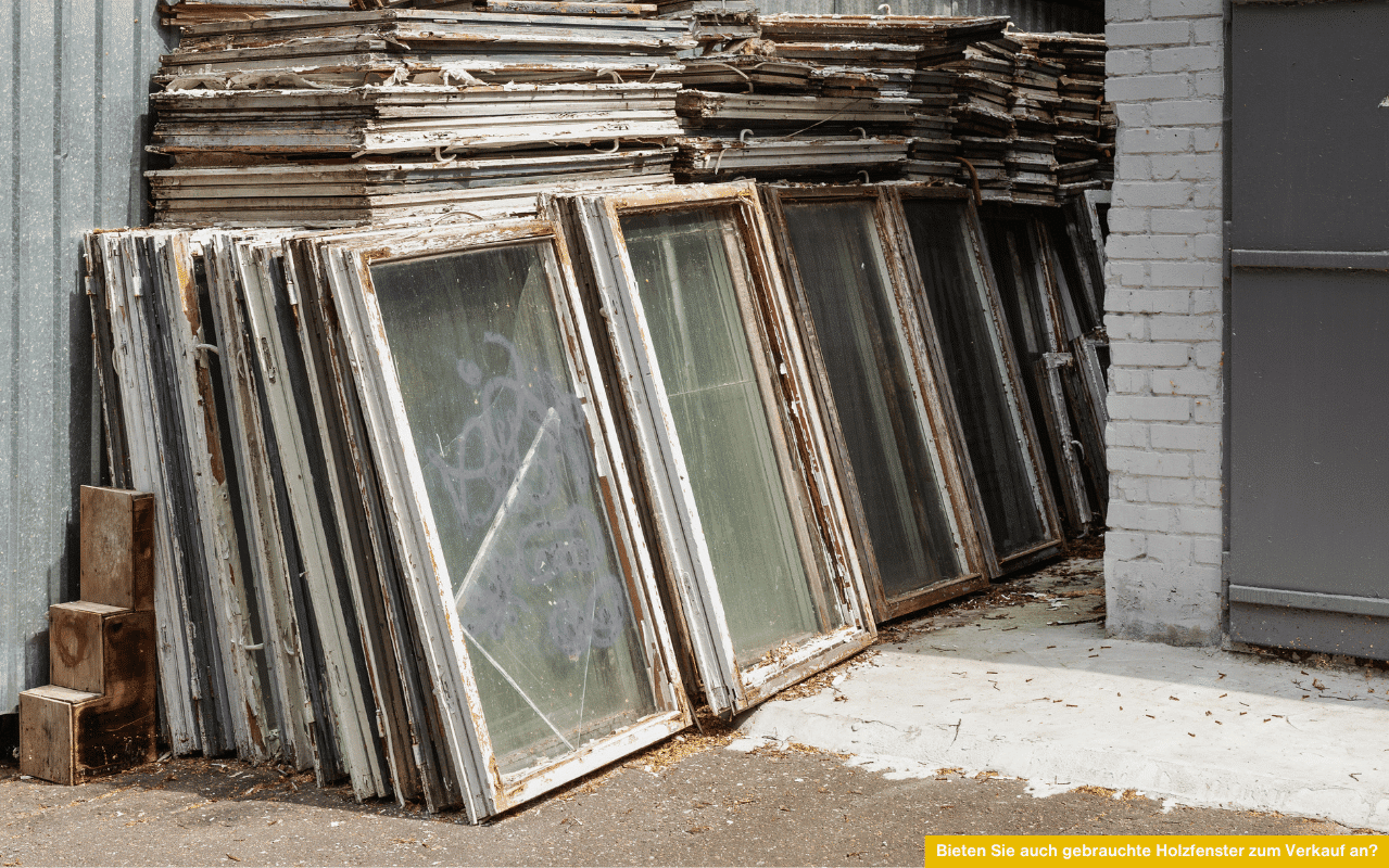Bieten Sie auch gebrauchte Holzfenster zum Verkauf an? Bild zeigt gestapelte, alte Holzfenster mit abgeplatzter Farbe und Glasscheiben.