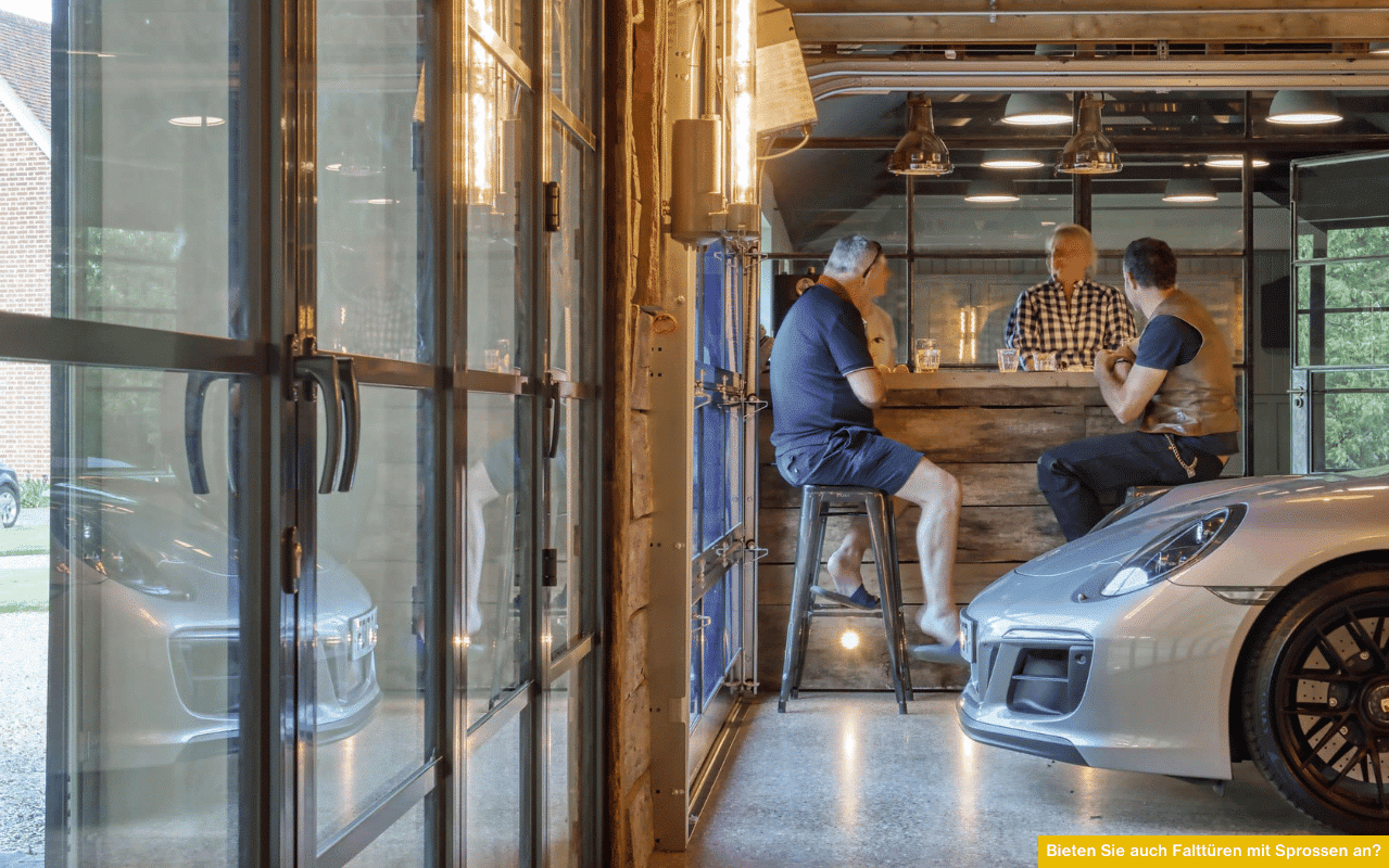 Bieten Sie Falttüren mit Sprossen an? Bild zeigt moderne Glas-Falttüren mit Sprossen in Garage mit Barbereich und Fahrzeug.