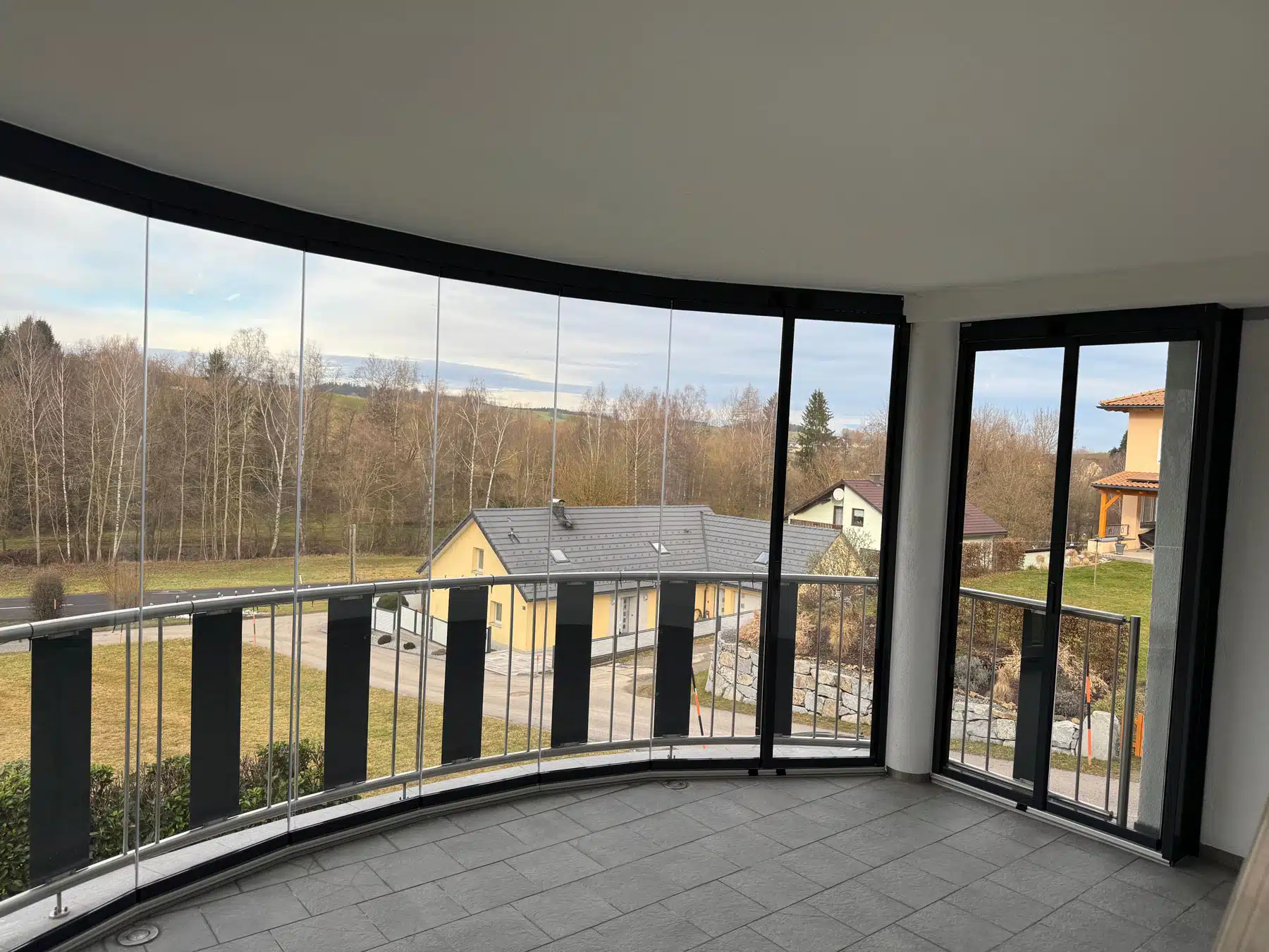 Bodentiefe Balkonverglasung mit Schiebe-Dreh-System Referenzen für optimale Transparenz und Wetterschutz