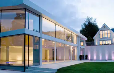 Modernes Wohnhaus mit großzügiger Glasfassade und stilvollen Eckfenstern für lichtdurchflutete Räume.