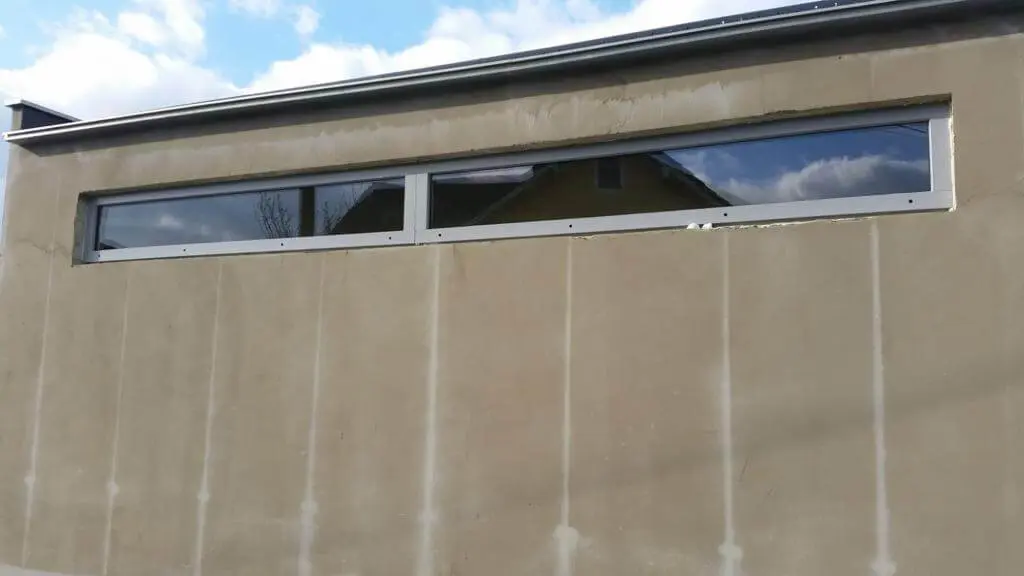 Ein neues Poolhaus mit schmalen Oberlicht-Fenstern entsteht