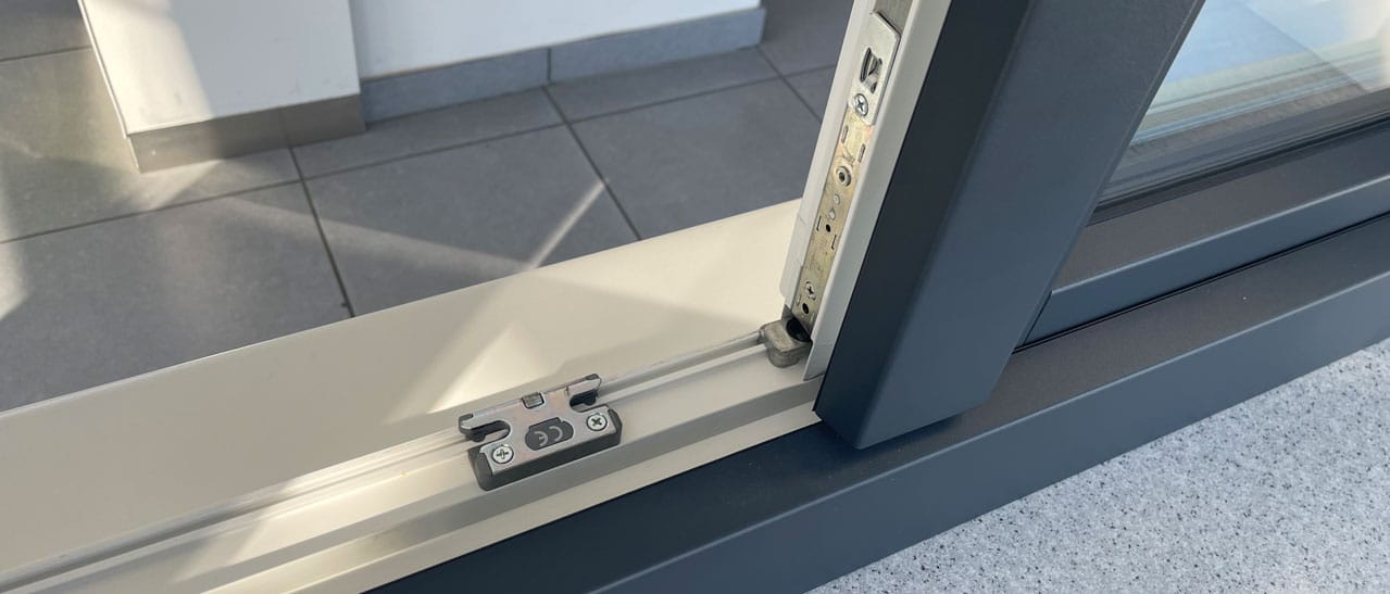 Das Foto zeigt den unteren Bereich eines geöffneten Stulpfensters. Sichtbar sind die hochwertigen Sicherheitsbeschläge und Verriegelungselemente, die für besseren Einbruchschutz und Stabilität bei modernen Fenstersystemen sorgen.