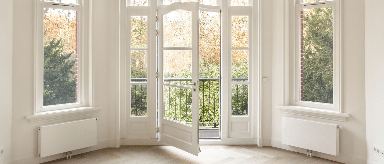 Innenansicht eines historischen Gebäudes mit Erkerfenster, Oberlichtern, Sprossen und einer eingebauten Terrassentür mit Seitenteilen.