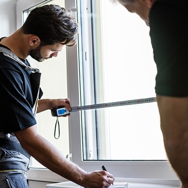 Fensterberater misst Fenster mit Maßblatt & Rollmeter für präzise Fenstermaße in Oberösterreich.