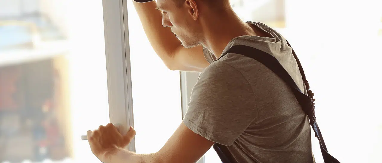 Servicetechniker justiert undichtes Fenster, sichert Verschluss und verhindert Lecks. Immer Fachmann für korrekte Einstellung konsultieren!