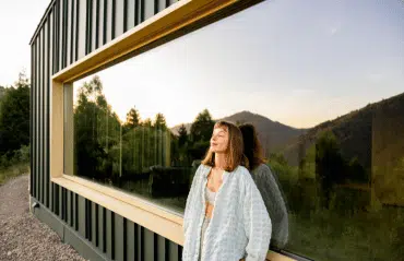 Fenster Hersteller Österreich – Fenster-Schmidinger mit großem Panoramafenster und moderner Architektur vor Bergkulisse bei Sonnenuntergang.
