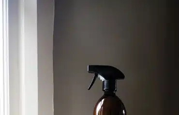 Fenster putzen im Winter Reinigungsspray vor einem Fenster für streifenfreie Sauberkeit und klare Sicht auch in der kalten Jahreszeit.