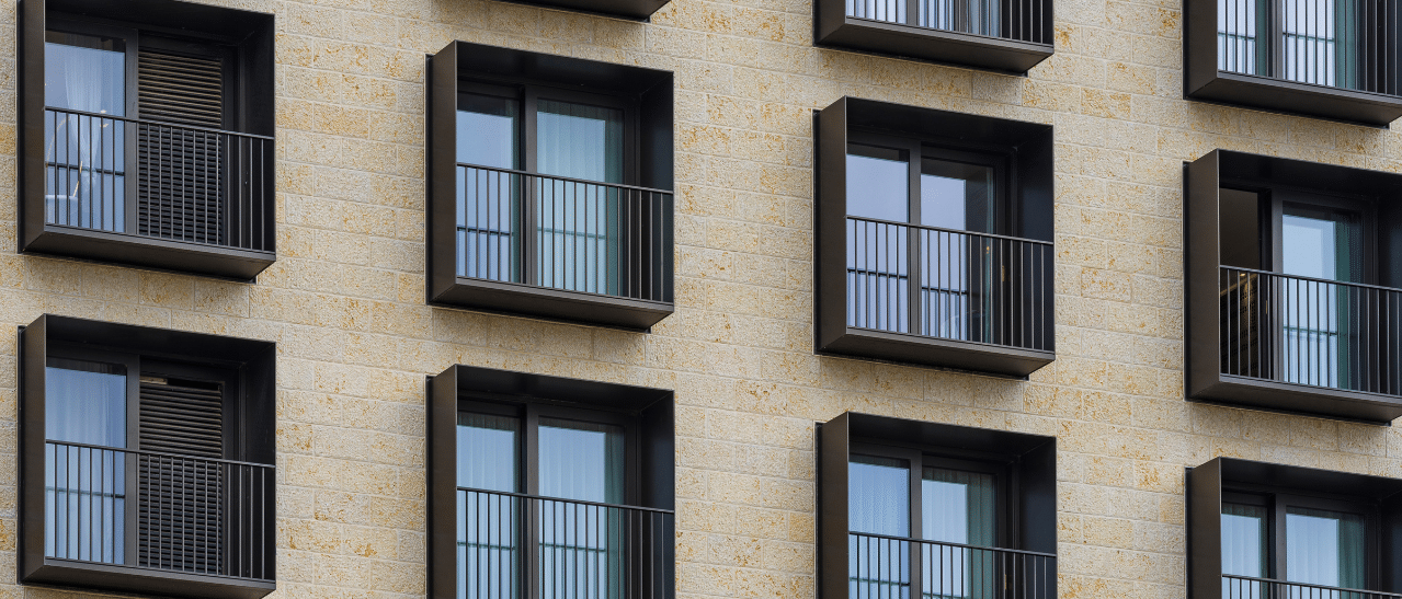 Fenster in einer dunklen Farben - Hier ein Beispiel von RAL 8019 Graubraunen Fenstern an moderner Fassade mit Steinoptik.