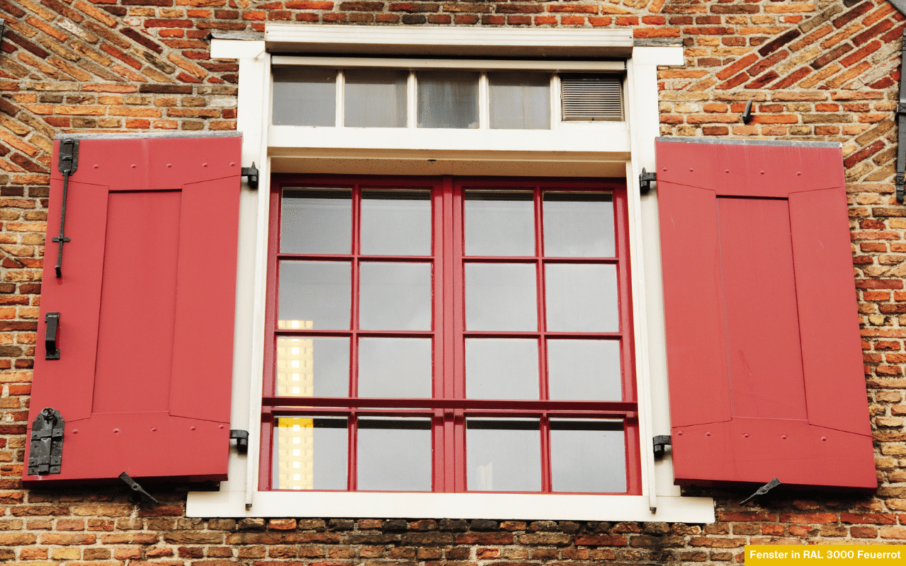 Fenster in RAL 3000 Feuerrot als stilvoller Akzent an Fassade mit roten Klappläden