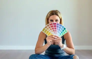 Junge Frau mit Handfächer von RAL-Farben, begeistert von der Farbe RAL 5007 Brillantblau für Fenster.