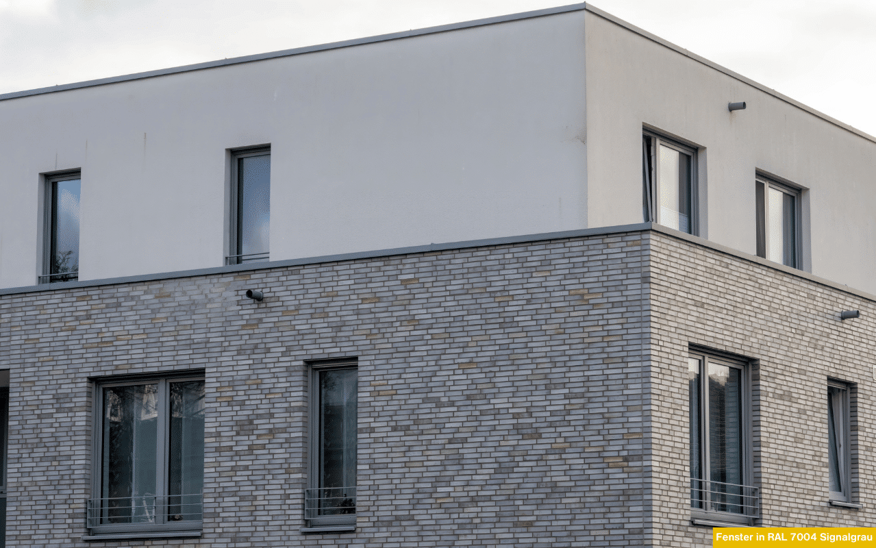 Fensterrahmen in RAL 7004 Signalgrau verbinden moderne Eleganz mit harmonischem Fassadendesign. Der helle Grauton wirkt ruhig, leicht und passt zu Stein-, Beton- oder Putzflächen – ideal für minimalistische Bauformen.