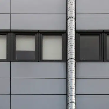 Eine moderne Metallfassade mit dunklen Fenstern in RAL 7024 Graphitgrau zeigt die Eleganz des Industrie-Designs. Der Farbton wirkt modern, dezent und sorgt für spannende Kontraste zu hellen Fassadenelementen.