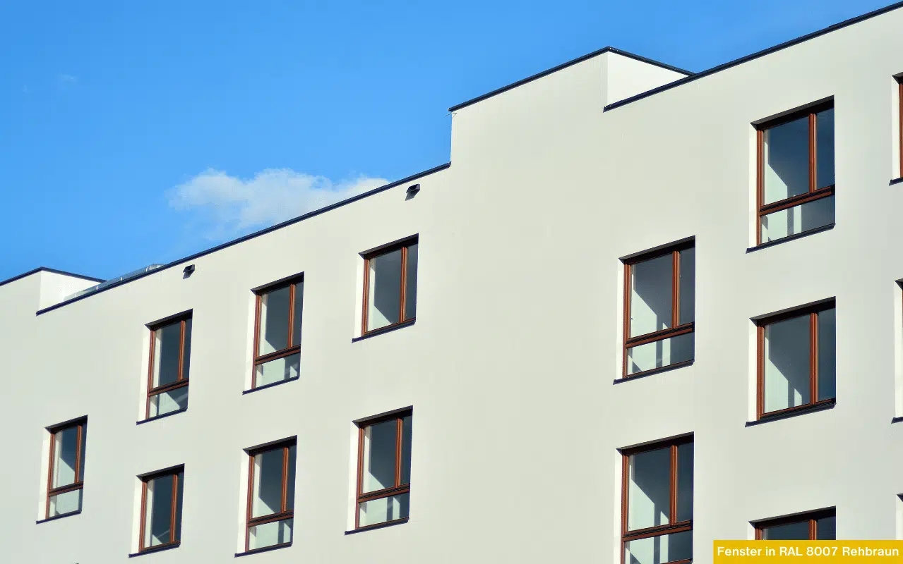 Fenster in RAL 8007 Rehbraun auf hellem Gebäudeteil mit zeitloser Architektur und warm abgesetzten Fensterrahmen