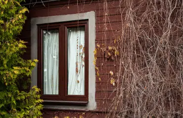 Fenster in RAL 8015 Kastanienbraun zeigt einen warmen, dunkelbraunen Holzton der natürlich mit Fassaden in Naturfarben harmoniert