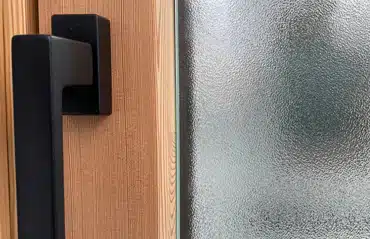 Detailansicht von Fenster mit Ornament 504 Glas und markanter Holzmaserung für modernen Sichtschutz