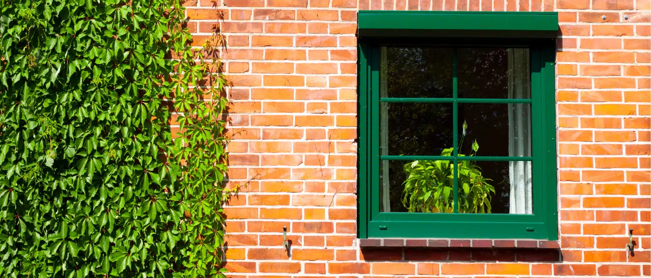 Ein Fenster in RAL 6005 moosgrün mit einem Vorsatzrollladen und einer Mehrfachverglasung, die effektiv die Kälte von draußen abschirmt.