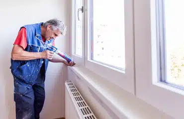 Der Monteur prüft die Abdichtung am Fenster. Sind meine Fenster dicht für besseren Wärmeschutz und Energieeinsparung im Zuhause?