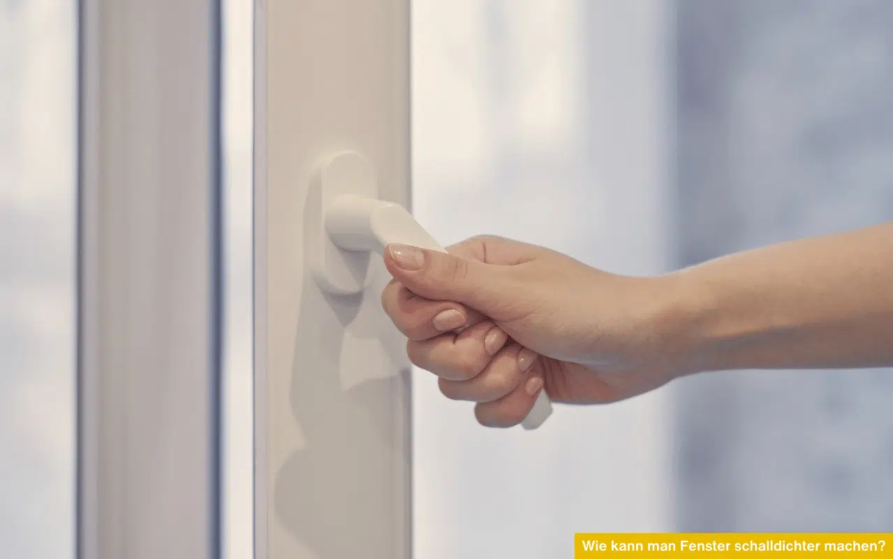 Nahaufnahme einer Hand, die einen weißen Fenstergriff betätigt – Fokus auf Anpressdruck und Schalldämmung.