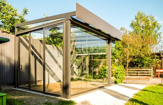 Sommergarten Made von Fa. Fenster-Schmidinger als freistehender Glasanbau mit Flachdach im Garten