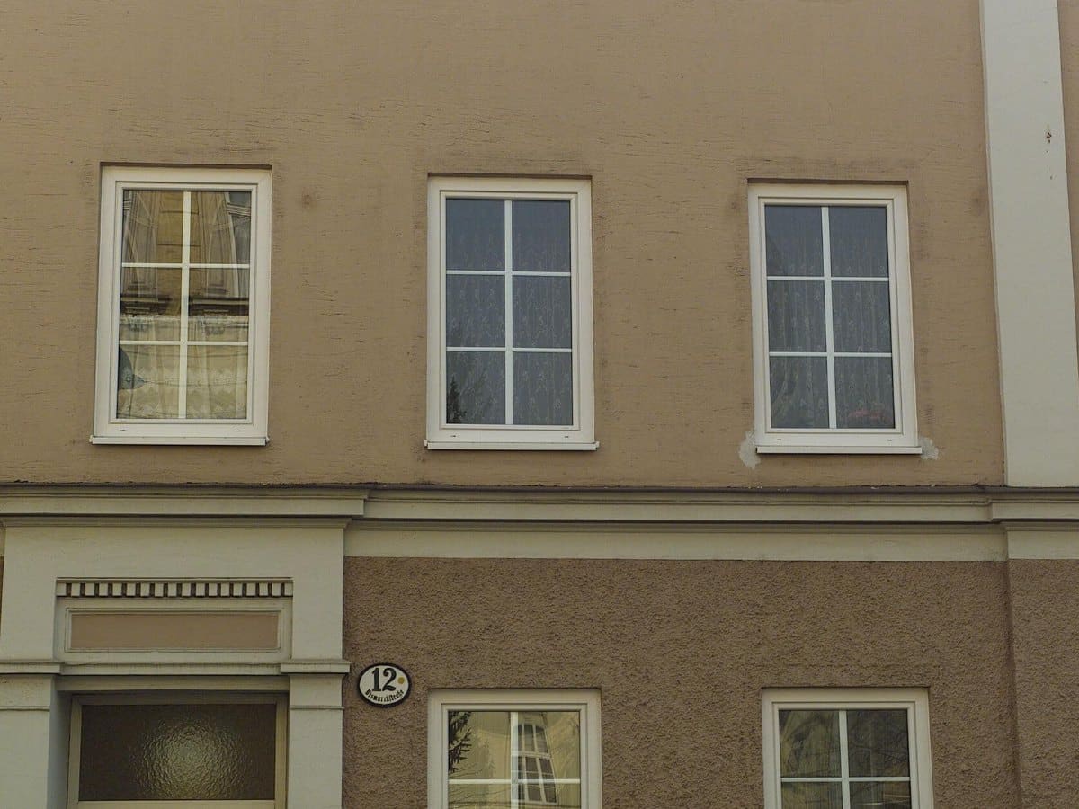 Altbaufassade mit neuen weißen Fenstern nach dem Fenstertausch, Sturz und Laibungen unverändert