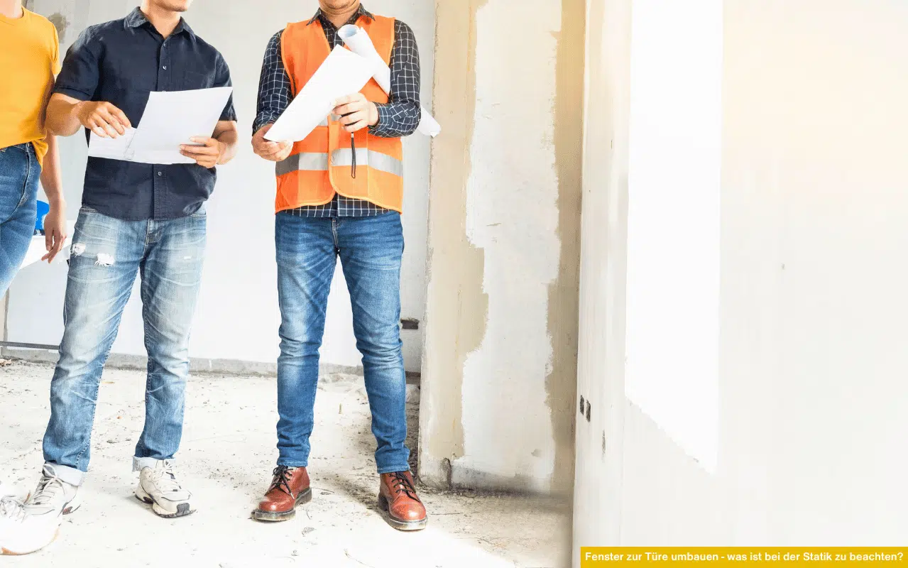 In einem Rohbau prüfen Bauleiter und Handwerker gemeinsam Pläne für den Umbau, während sie im staubigen Raum stehen.