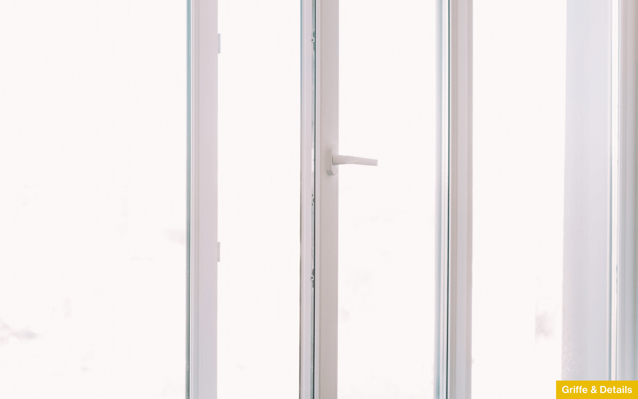 Detailaufnahme eines modernen Fenstergriffs an einem hellen Profil - Fokus auf die Abstimmung von Griff und Rahmenfarbe.