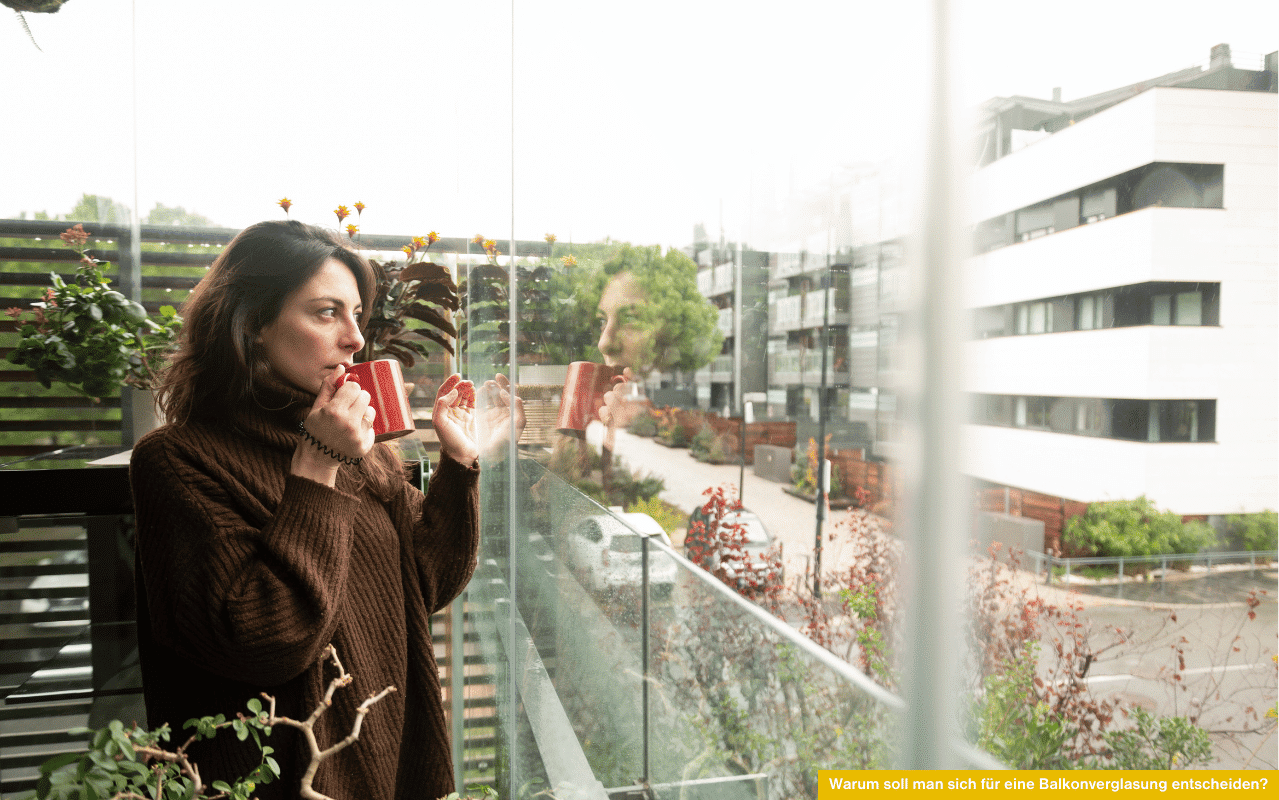 Frau mit Tasse auf verglastem Balkon - Warum soll man sich für eine Balkonverglasung entscheiden und welche Vorteile bringt sie?