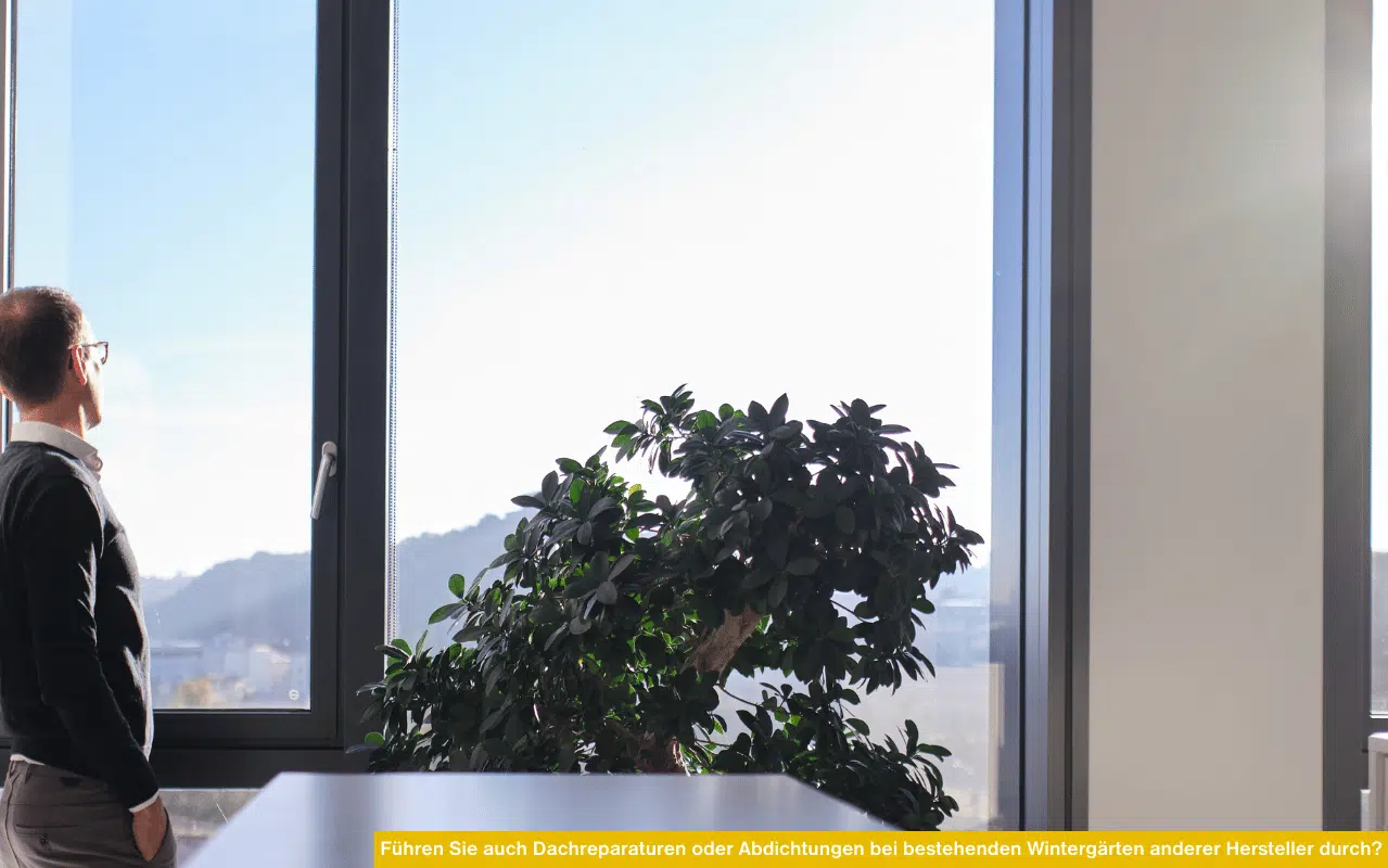 Führen Sie auch Dachreparaturen oder Abdichtungen bei bestehenden Wintergärten anderer Hersteller durch zeigt Mann am Fenster mit Ausblick ins Freie.