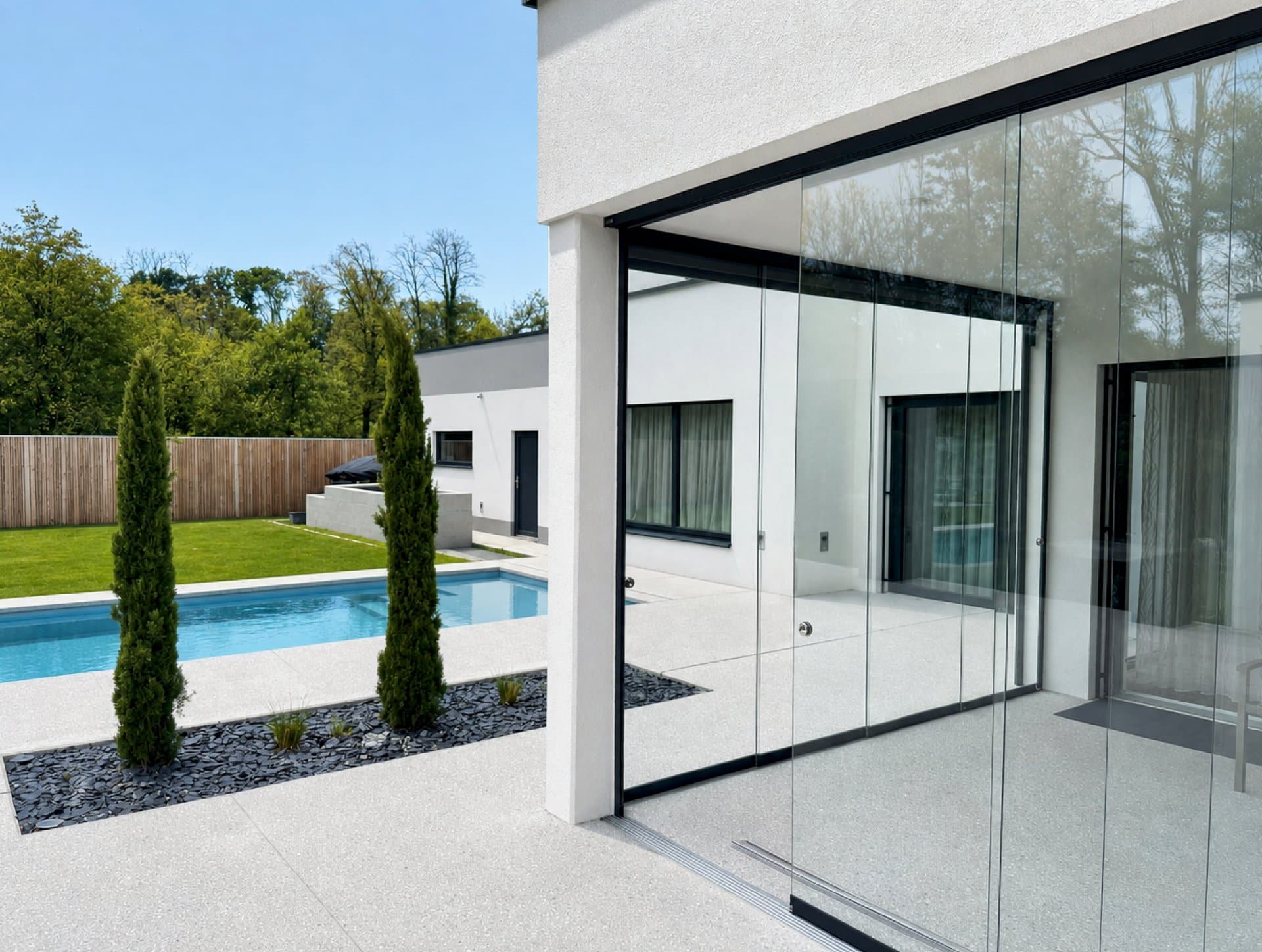 Ganzglas-Schiebetüren an der Terrasse mit Blick zum Pool