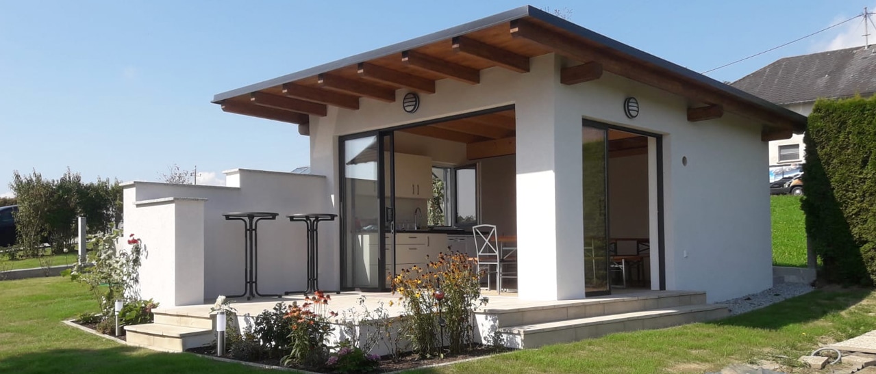 Modernes Gartenhaus mit filigranen Schiebetüren aus Isolierglas und Pultdach