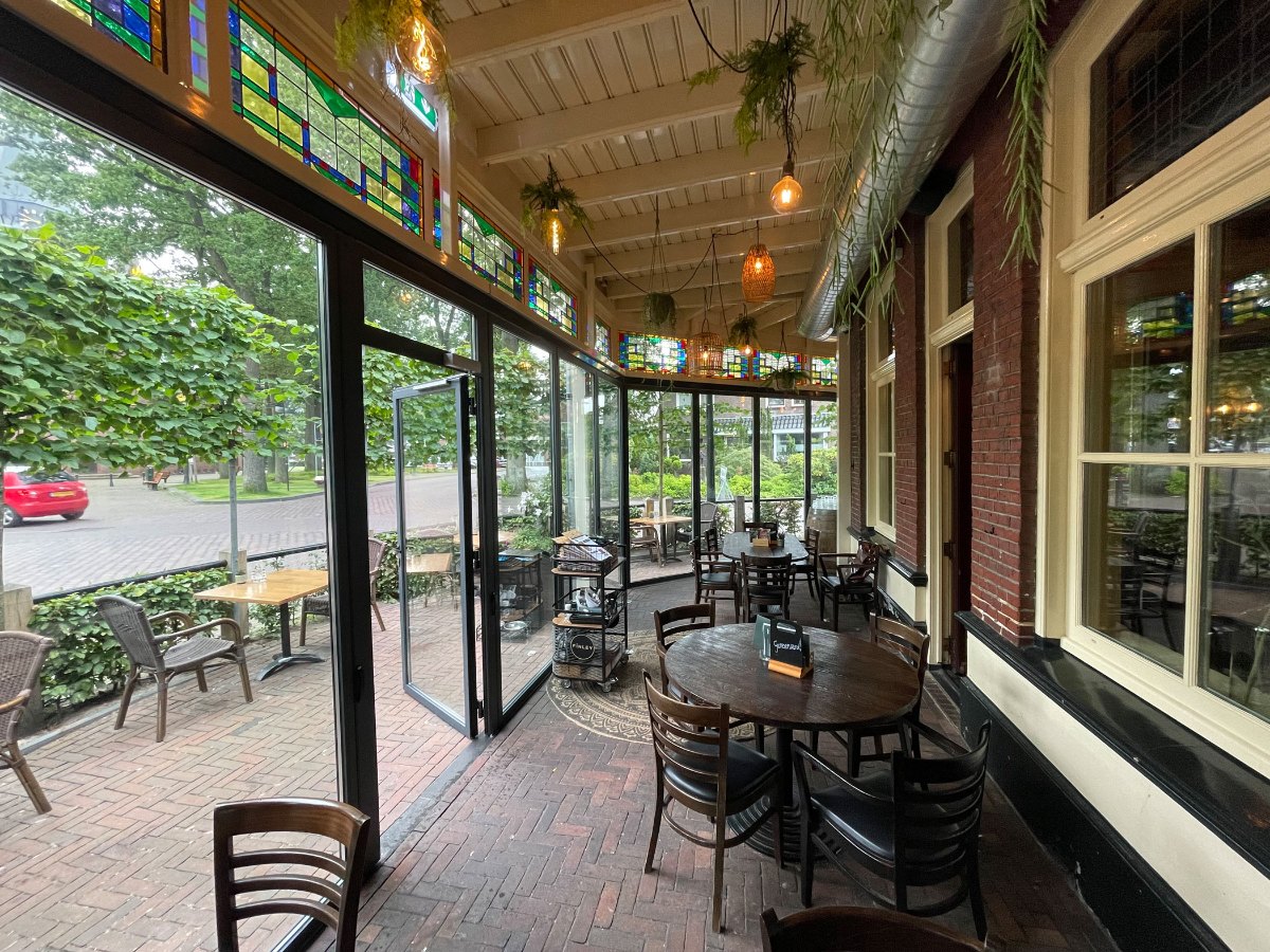 Gastro-Wintergarten mit umlaufender Verglasung und Blick in den Gastraum