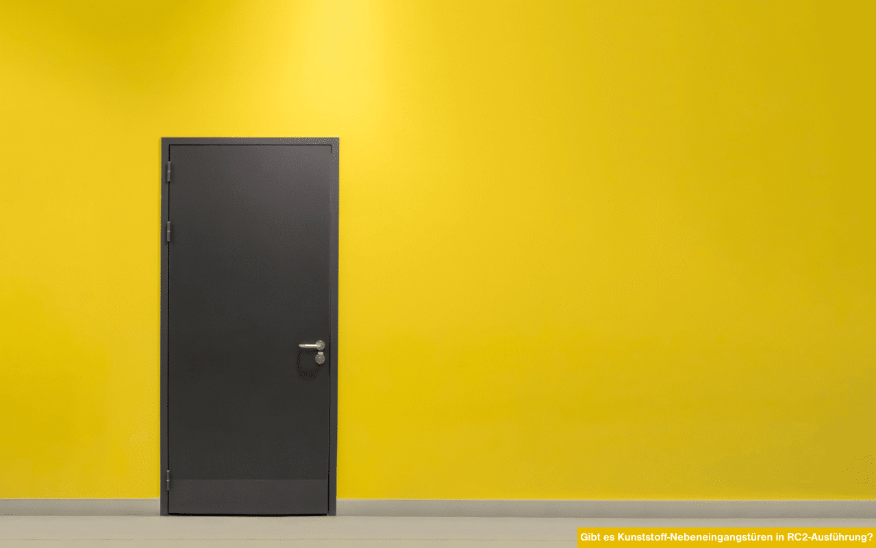 Das Bild zeigt eine moderne graue Kunststofftür vor einer gelben Wand. Diese Art von Nebeneingangstür kann in RC2-Ausführung erhältlich sein.