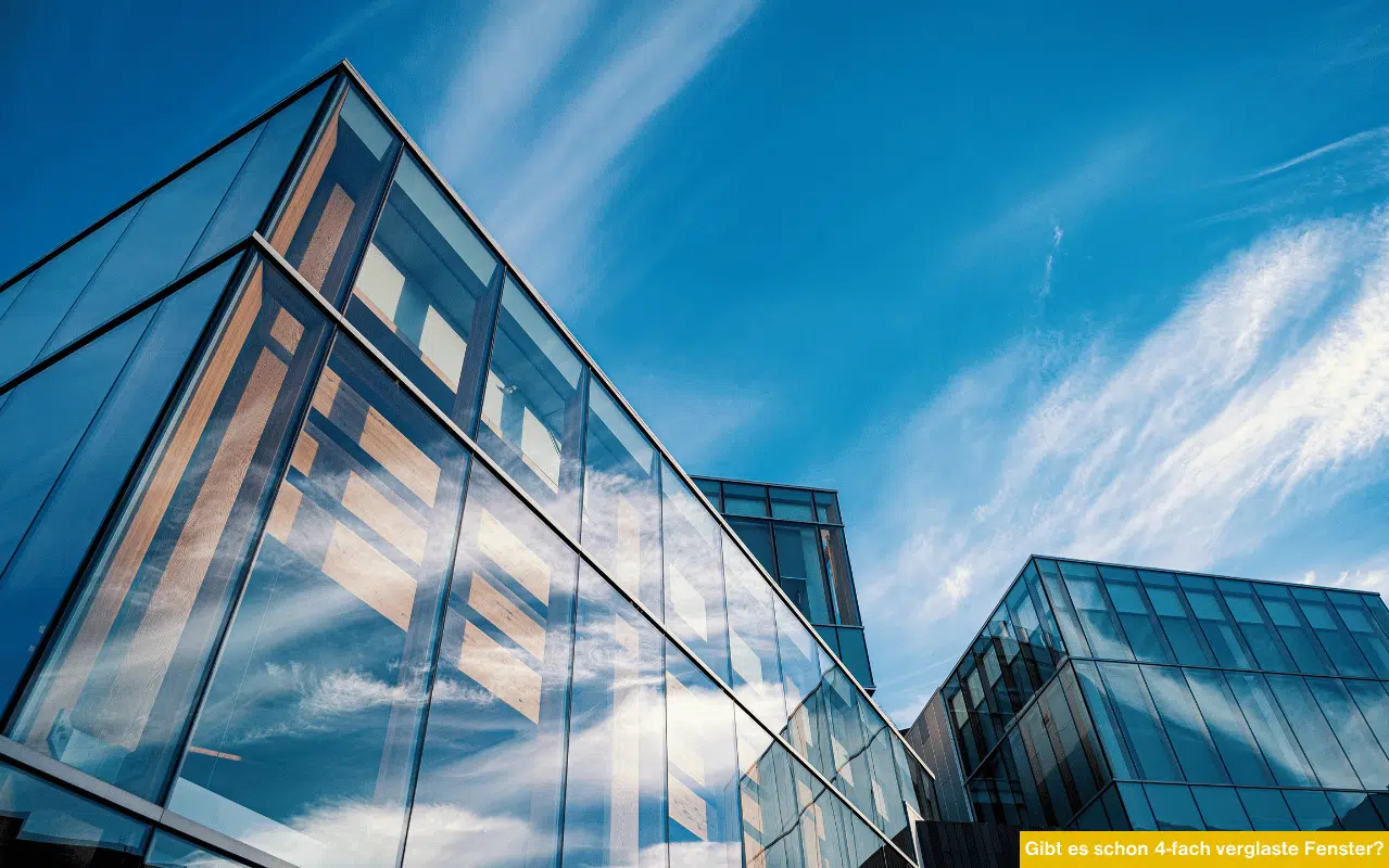 Gibt es schon 4-fach verglaste Fenster Moderne Glasfassade mit Spiegelung des Himmels zeigt Zukunftstrend in energieeffizienter Verglasung.