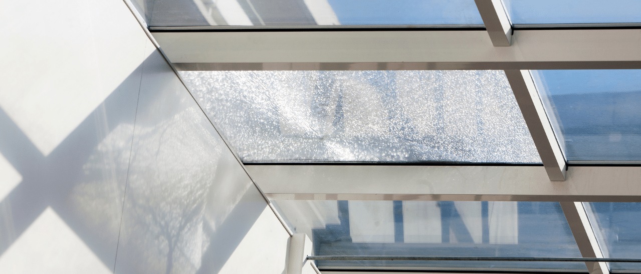 Glasbruch bei Wintergarten-Dach beschädigte Dachverglasung mit sichtbarem Bruchmuster im Glas.